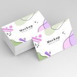 Stack of smooth silk standard business cards with modern abstract design in pastel colours, printed double-sided