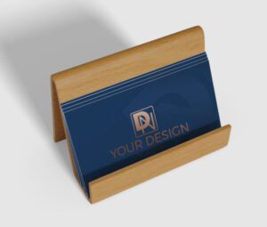 Elegant Spot UV business card mockup in a wooden holder, featuring a deep blue design with a shiny gold logo, perfect for vibrant branding.
