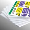Stack of white 5mm hard Foamex boards with a top sheet showing site safety sign like "High visibility jackets must be worn".