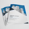 Stack of professional A4 laminated cover booklets featuring an 'Annual Report' design with a city skyline graphic.