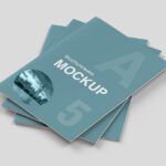 Stack of professional A5 hard cover booklet mockups with a teal cover, ideal for compact brochures or guides.