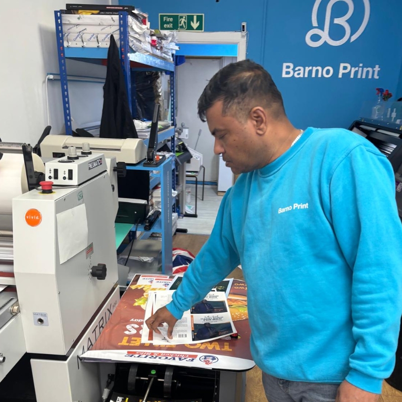 Man performing commercial printing services on a press at Barno Print, East London